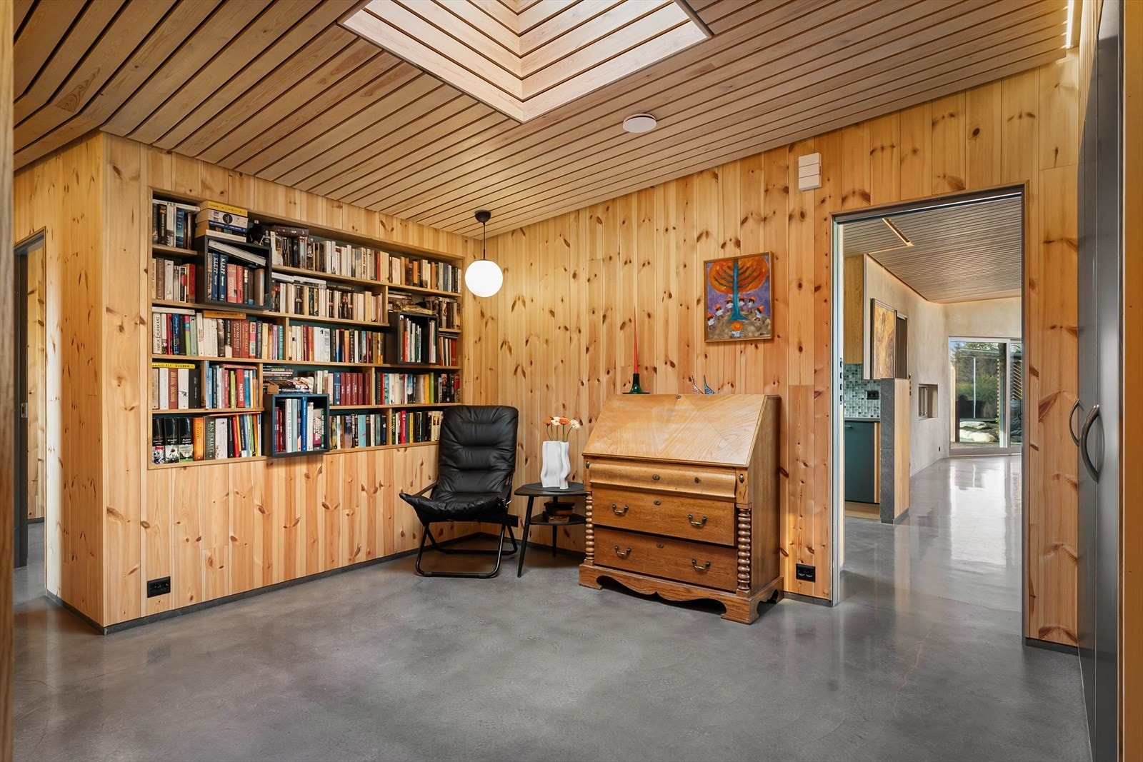I midten har du en fredelig lesekrok med innfelte bokhyller og en detalj i taket som sørger for fint lys og den hyggelige lyden av regnet som trommer på ruta. Galleribilde
