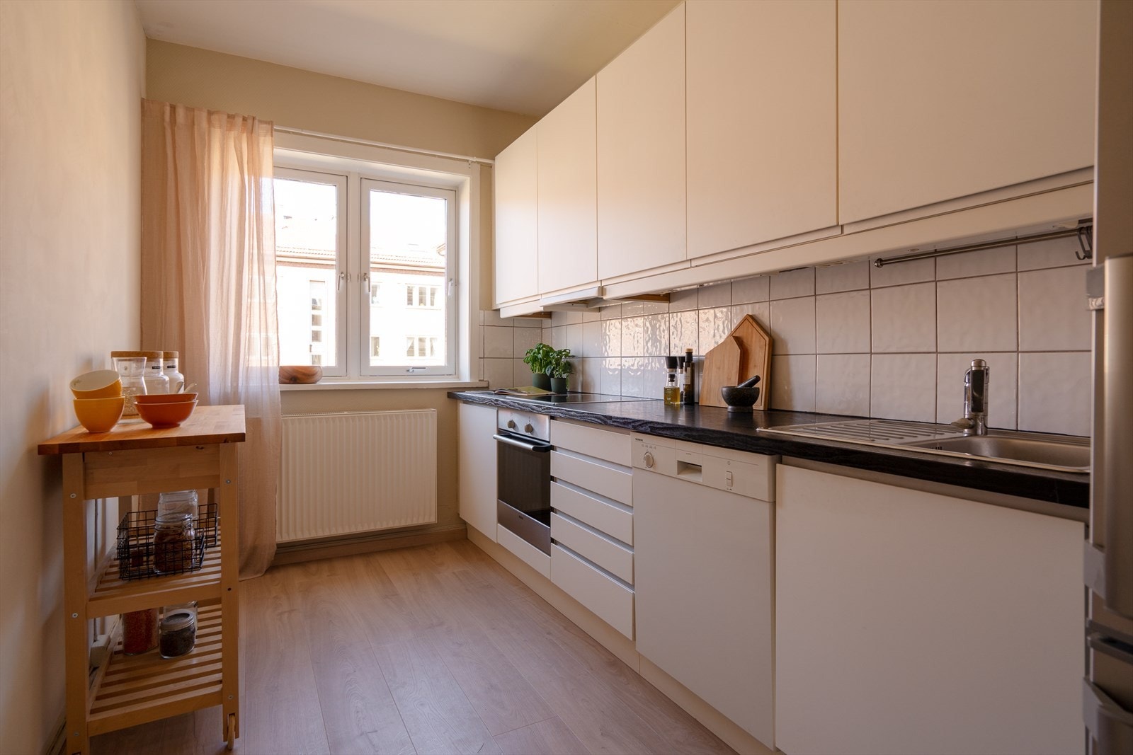 Det praktiske kjøkkenet har innredning fra IKEA med profilerte fronter og foliert benkeplate. Galleribilde