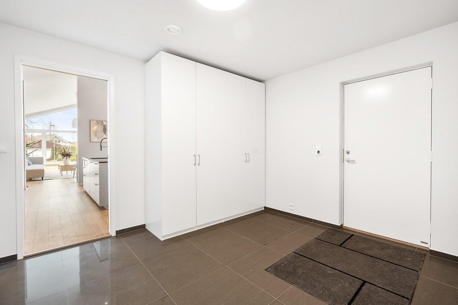 Stort vaskerom med innredning og videre inngang til garasjen Galleribilde