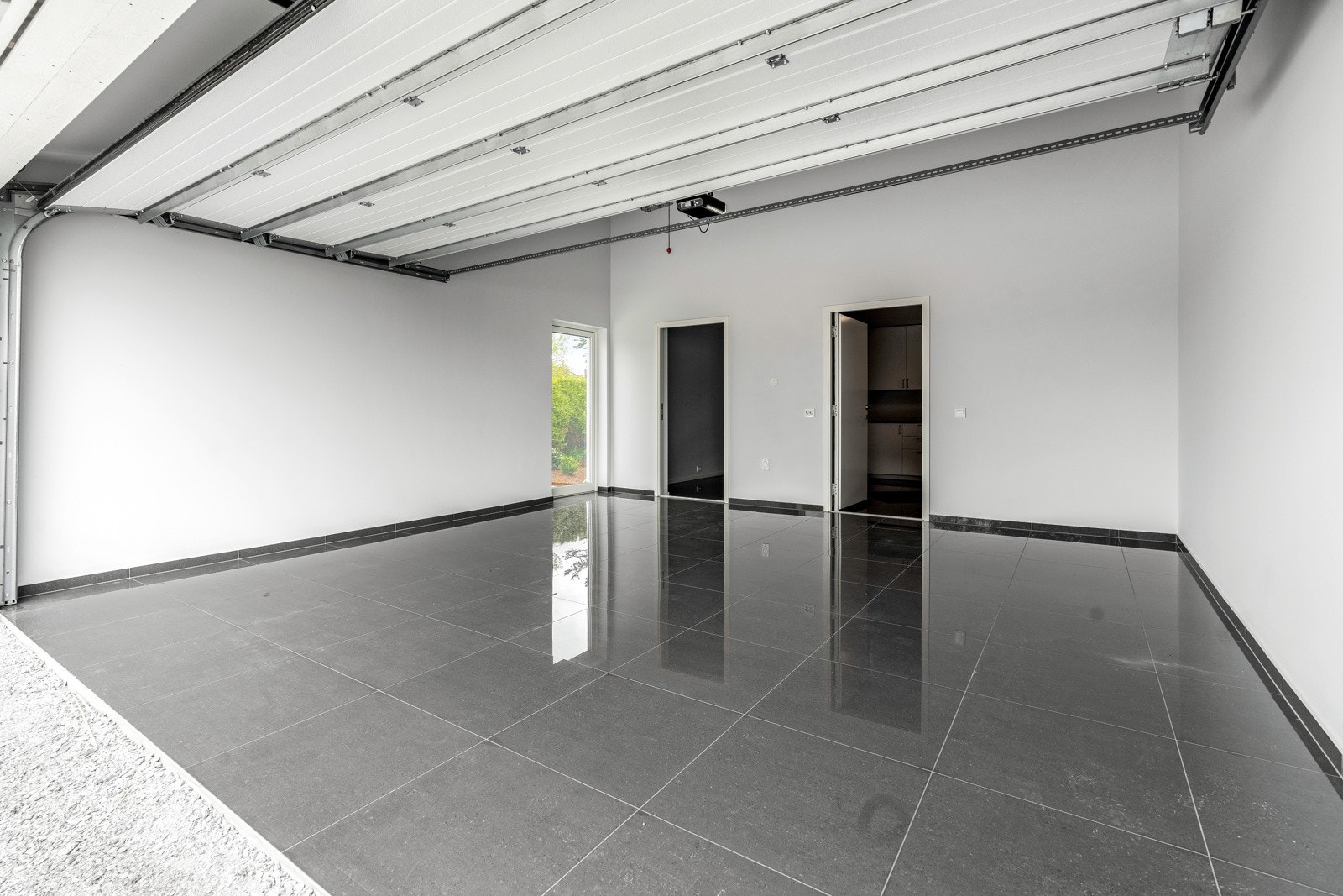 Fullisolert garasje med malte vegger og flislagt gulv Galleribilde