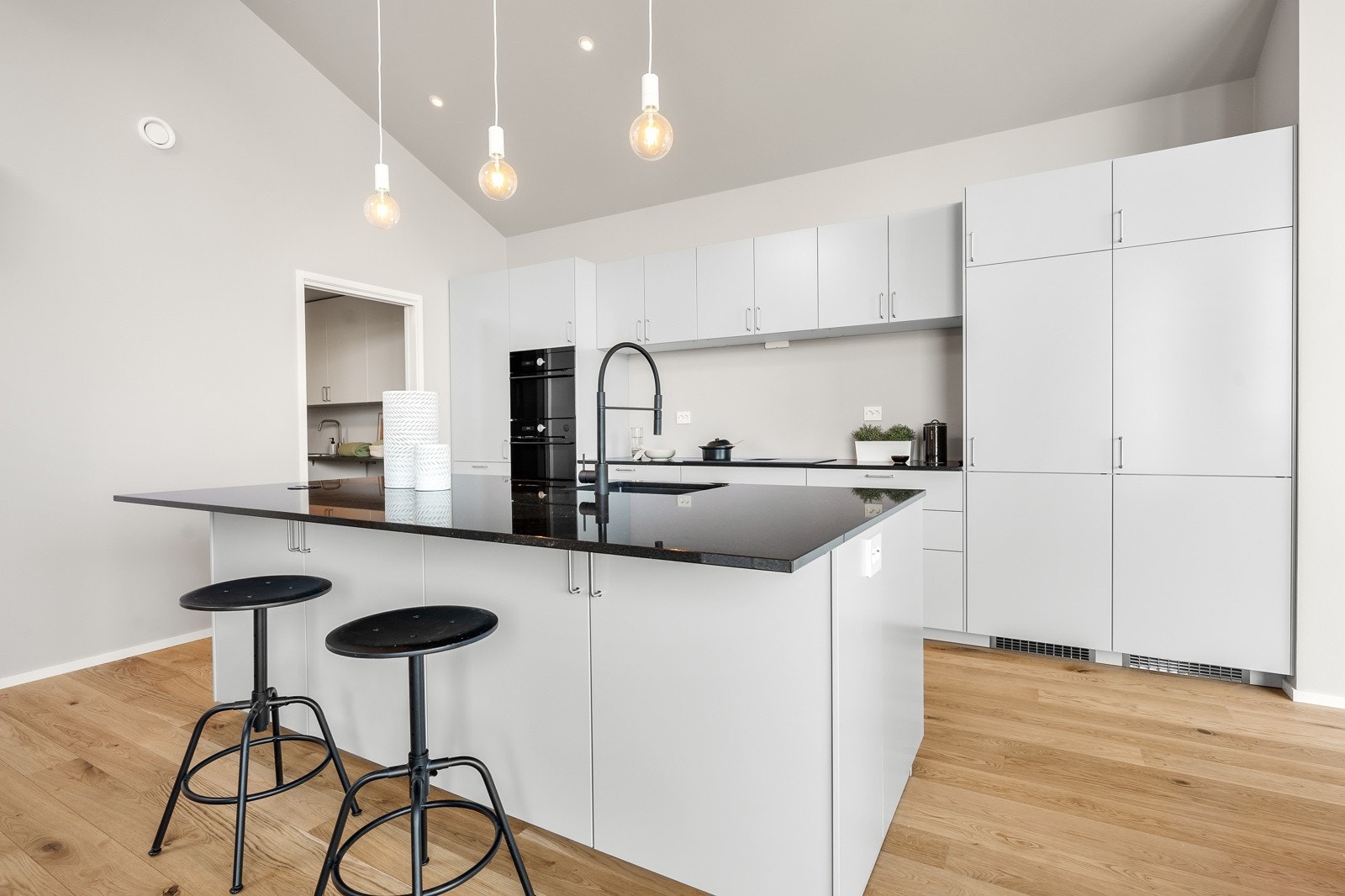 Lekkert og velutstyrt kjøkken med øy med spiseplass og nedfelte stikkontakter Galleribilde