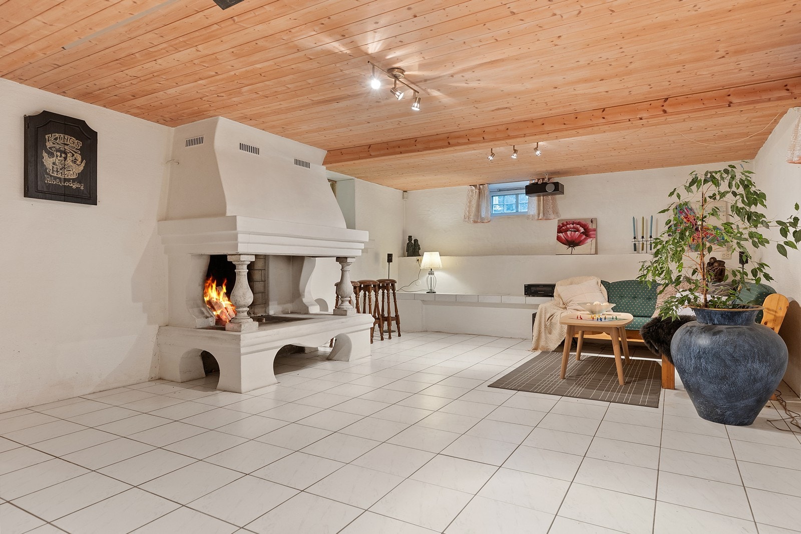 Kjellerstue med stor plass til ulike aktivitetssoner - Flott peis, som er plassert sentralt i rommet Galleribilde