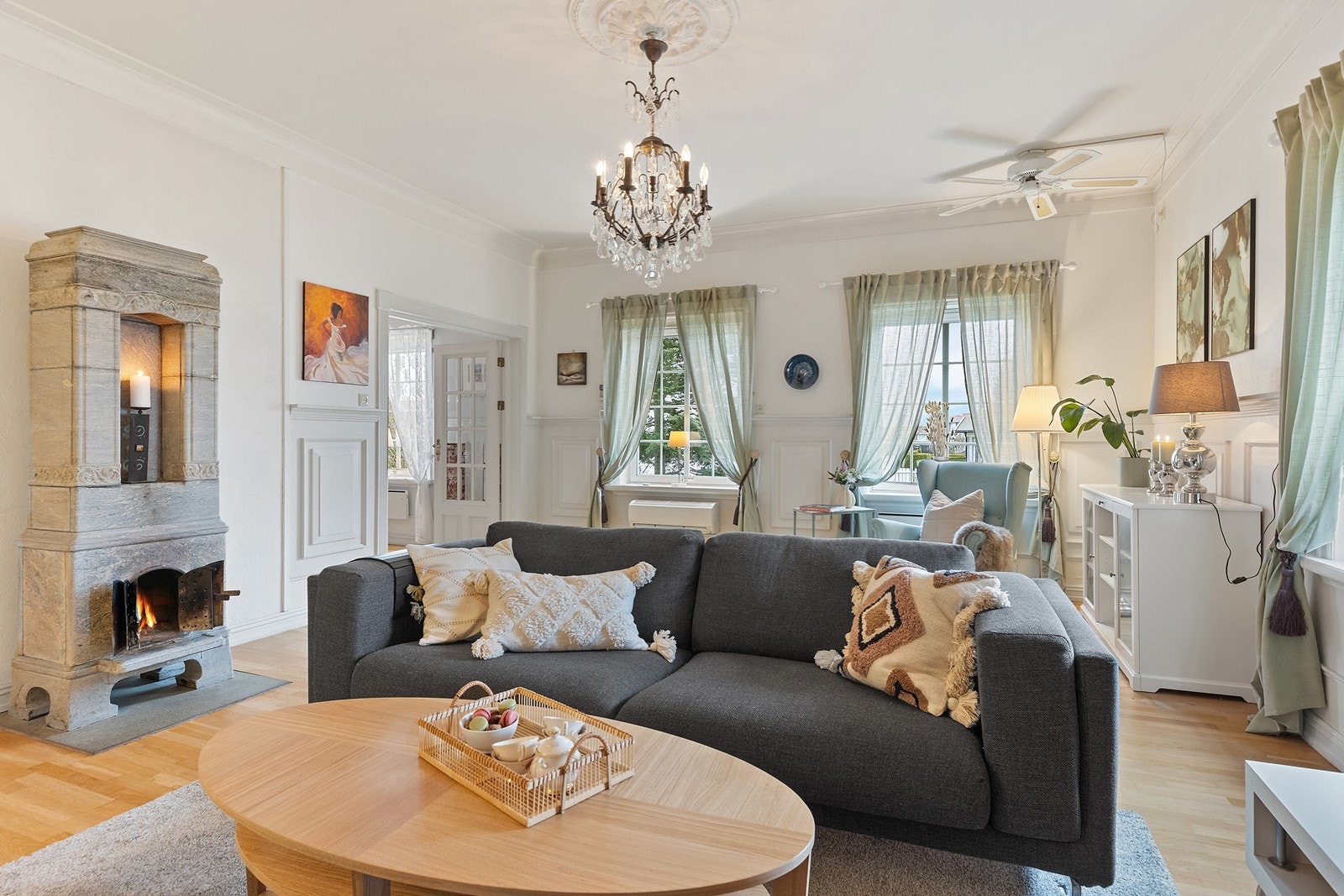 Rosett i taket, brystningspanel, lysekrone og dekorativ klebersteinsovn Galleribilde