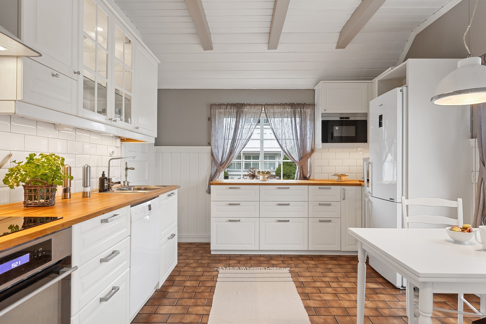 Kjøkkenet har integrert platetopp, stekeovn og Micro. Benkeplate i heltre med fliser over benkeplaten. Galleribilde