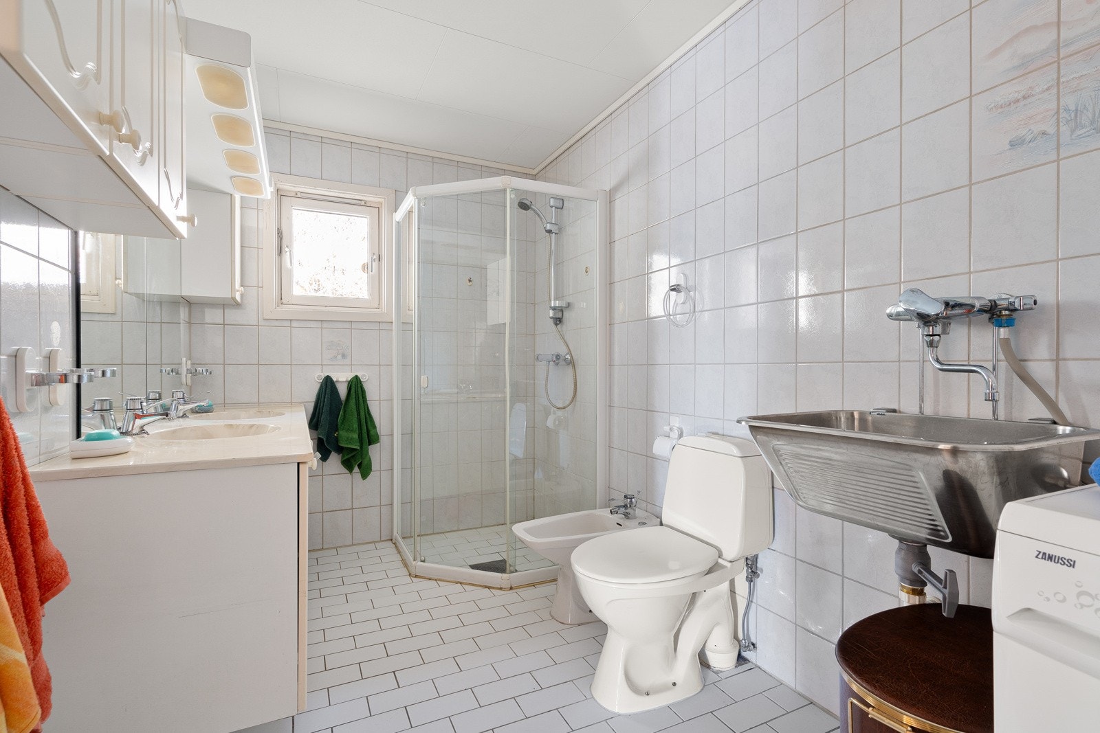 Bad - 1 etasje. Flislagt gulv med gulvvarme. Speil med overlys og stikkontakt over servant. Wc og dusjhjørne. Galleribilde