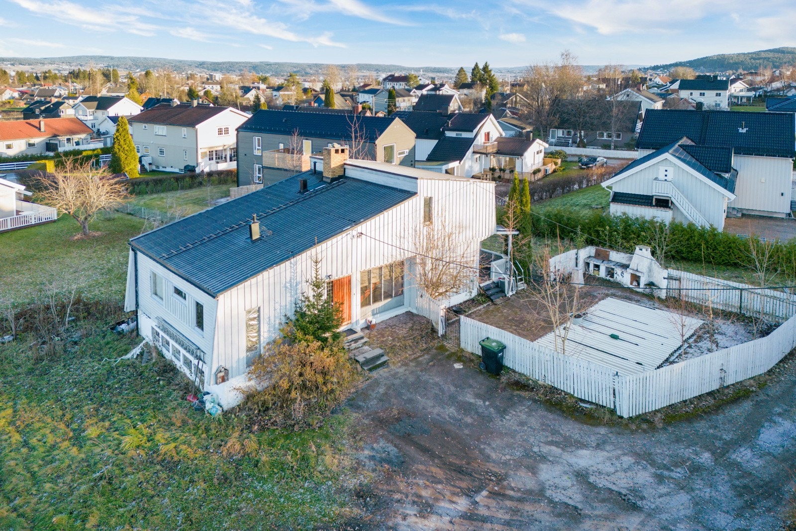 Tomten er opparbeidet med gressplen, buske og hekk, og har gruset gårdplass. Bassengen er inngjerdet. Galleribilde