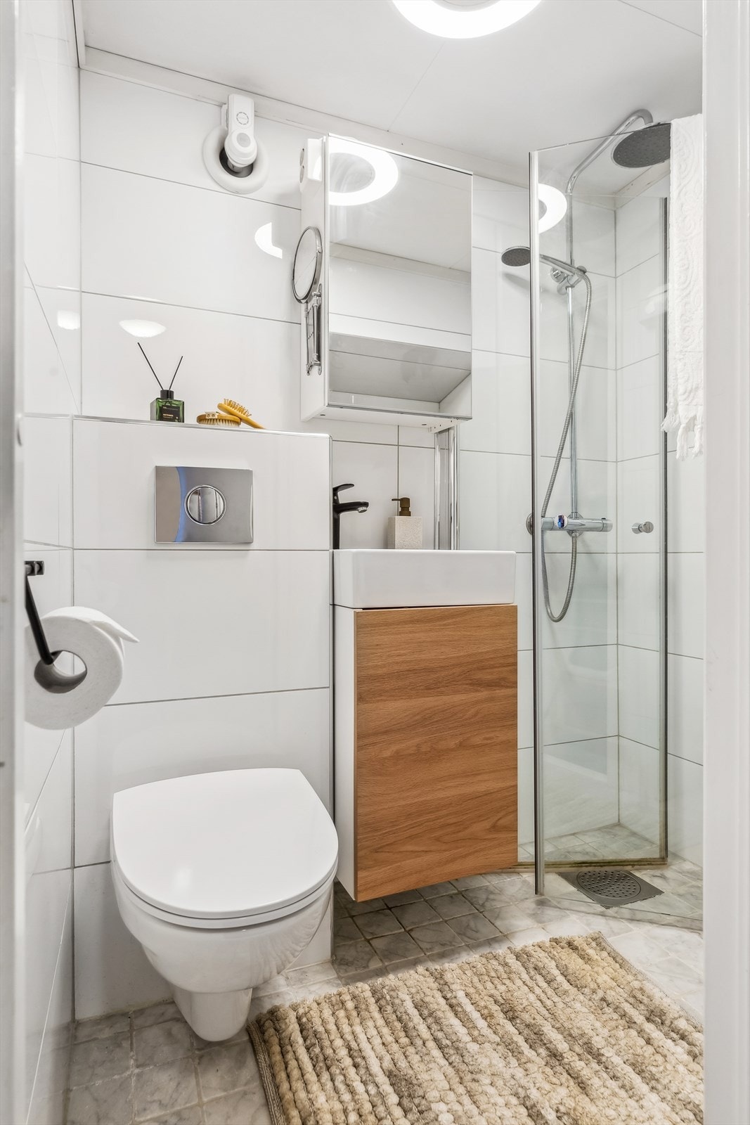 Leilighetens bad er stilrent og helfliset. Baderommet ble oppgradert i 2016, i likhet med kjøkkenet. Galleribilde