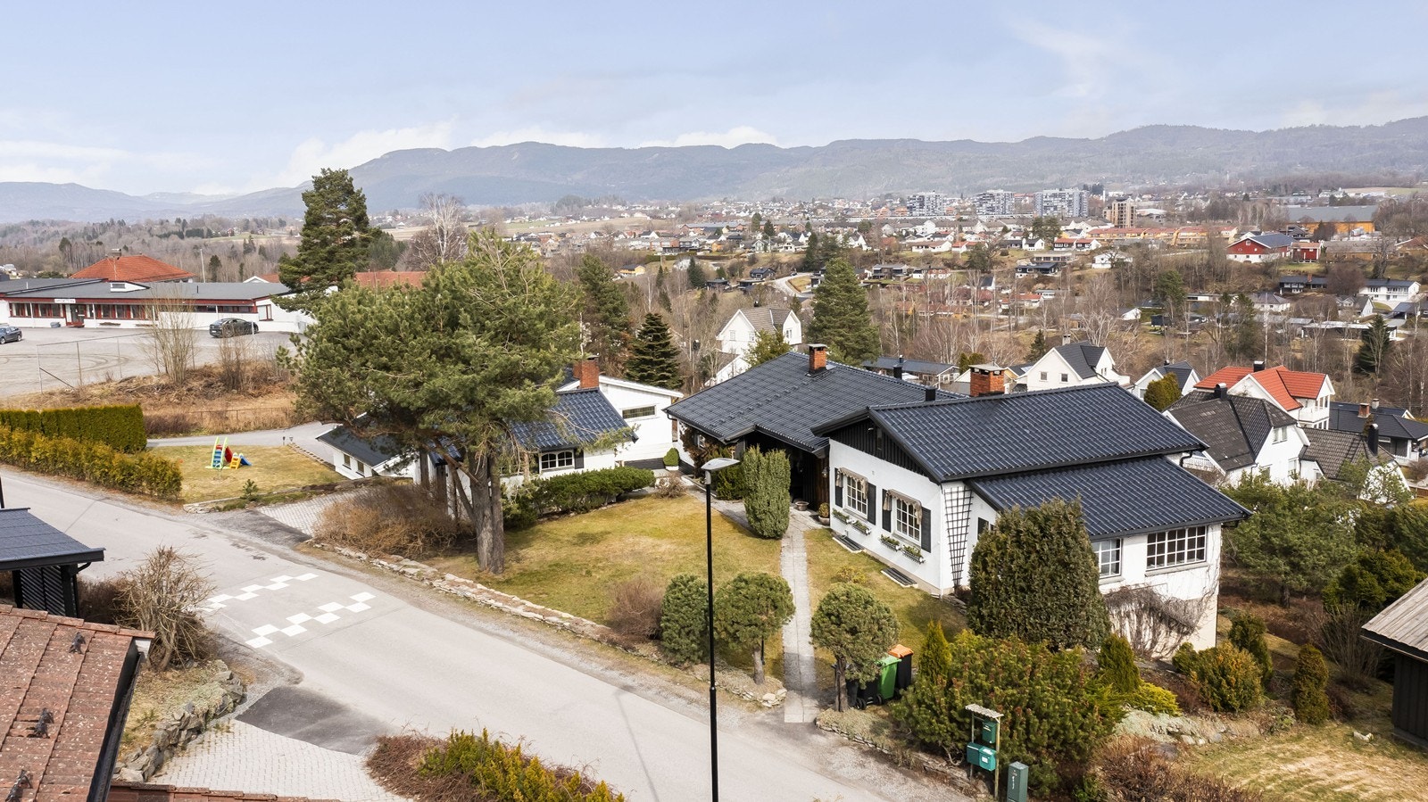 Tomten består av planert gårdsrom med plen, gangbaner, veranda og garasje. Galleribilde