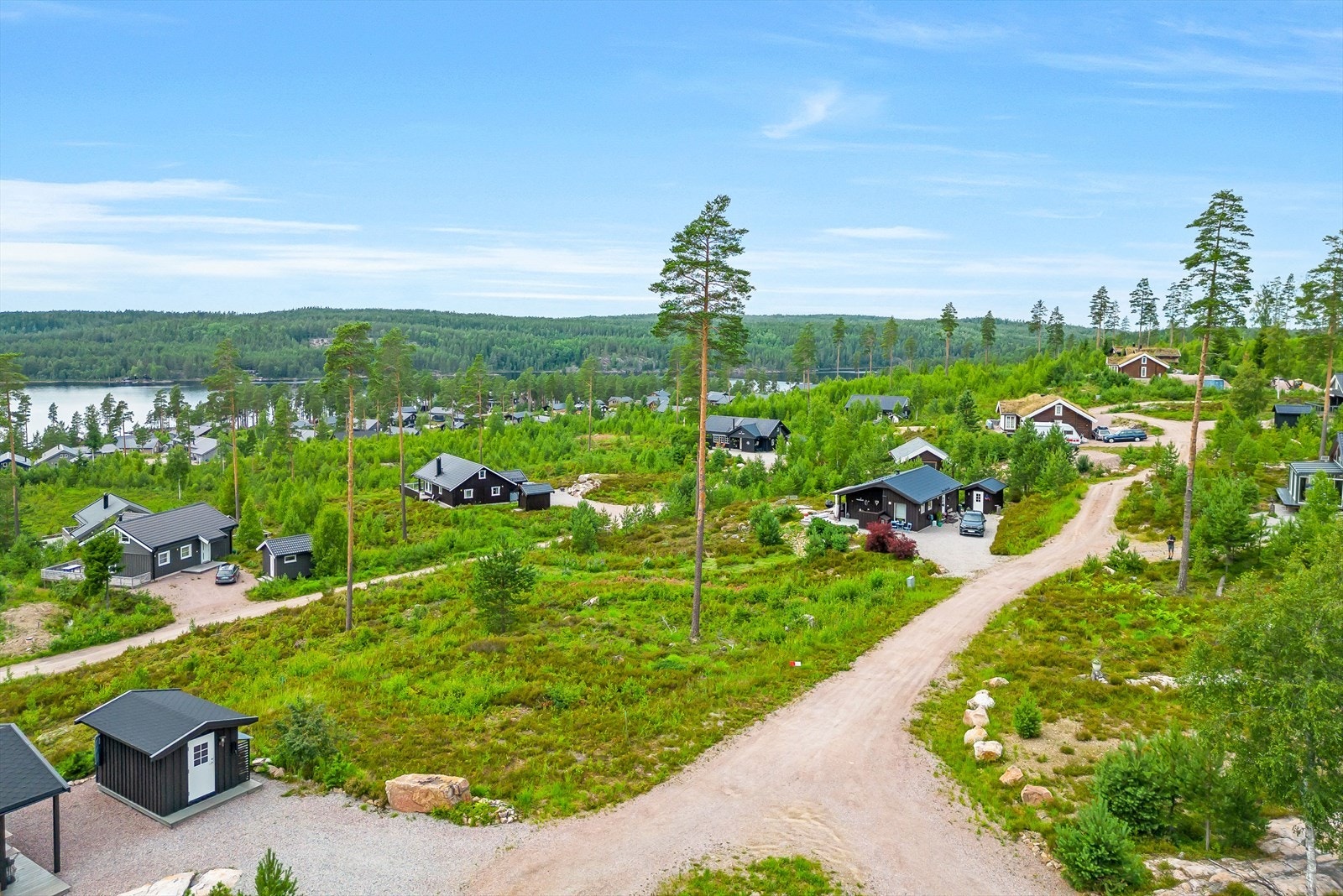 Kupert tomt med fjell i dagen, noe trær samt diverse vegetasjon Galleribilde