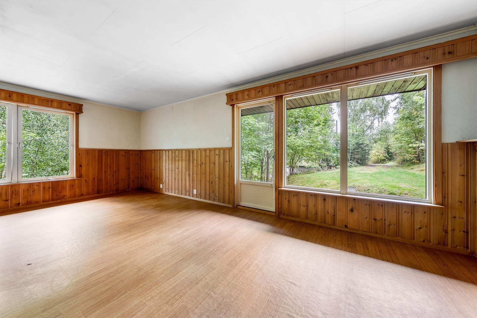Fra stuen er det utgang til stor terrasse med usjenert utsyn mot omliggende grøntområder. Galleribilde
