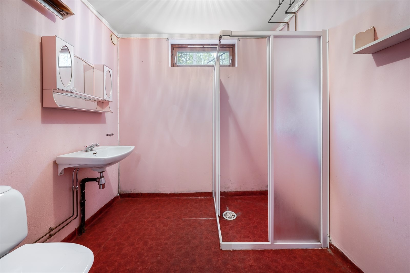 Badet i underetasjen inneholder toalett, vask og dusj på vegg med dusjvegger. Galleribilde
