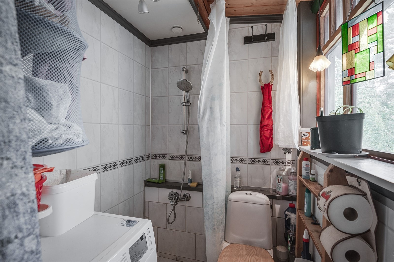 Bad i fritidsboligen, med toalett og dushjørne med forheng. Galleribilde