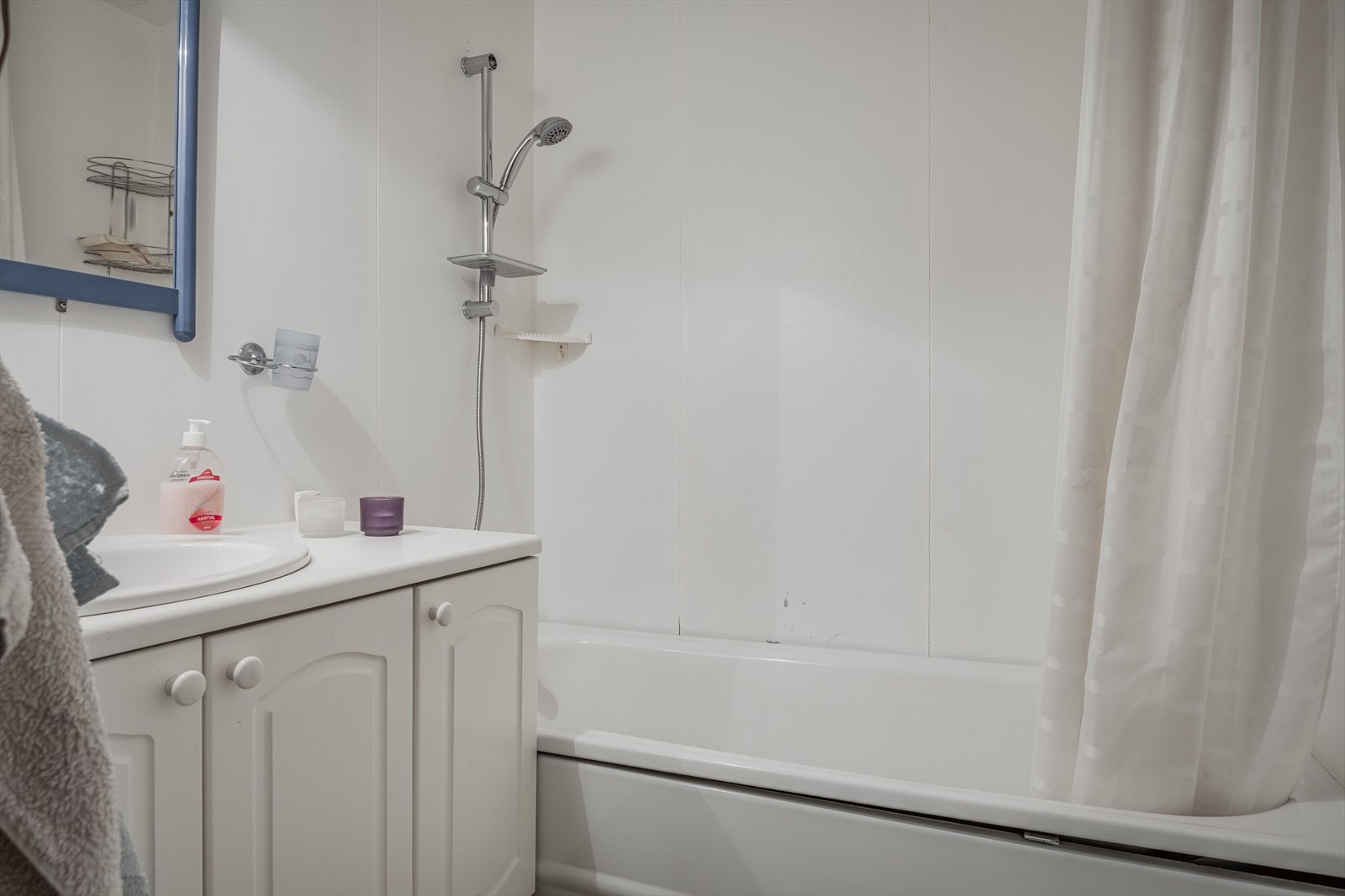 Badet er innredet med servant på innredning, toalett og badekar med dusj. Galleribilde