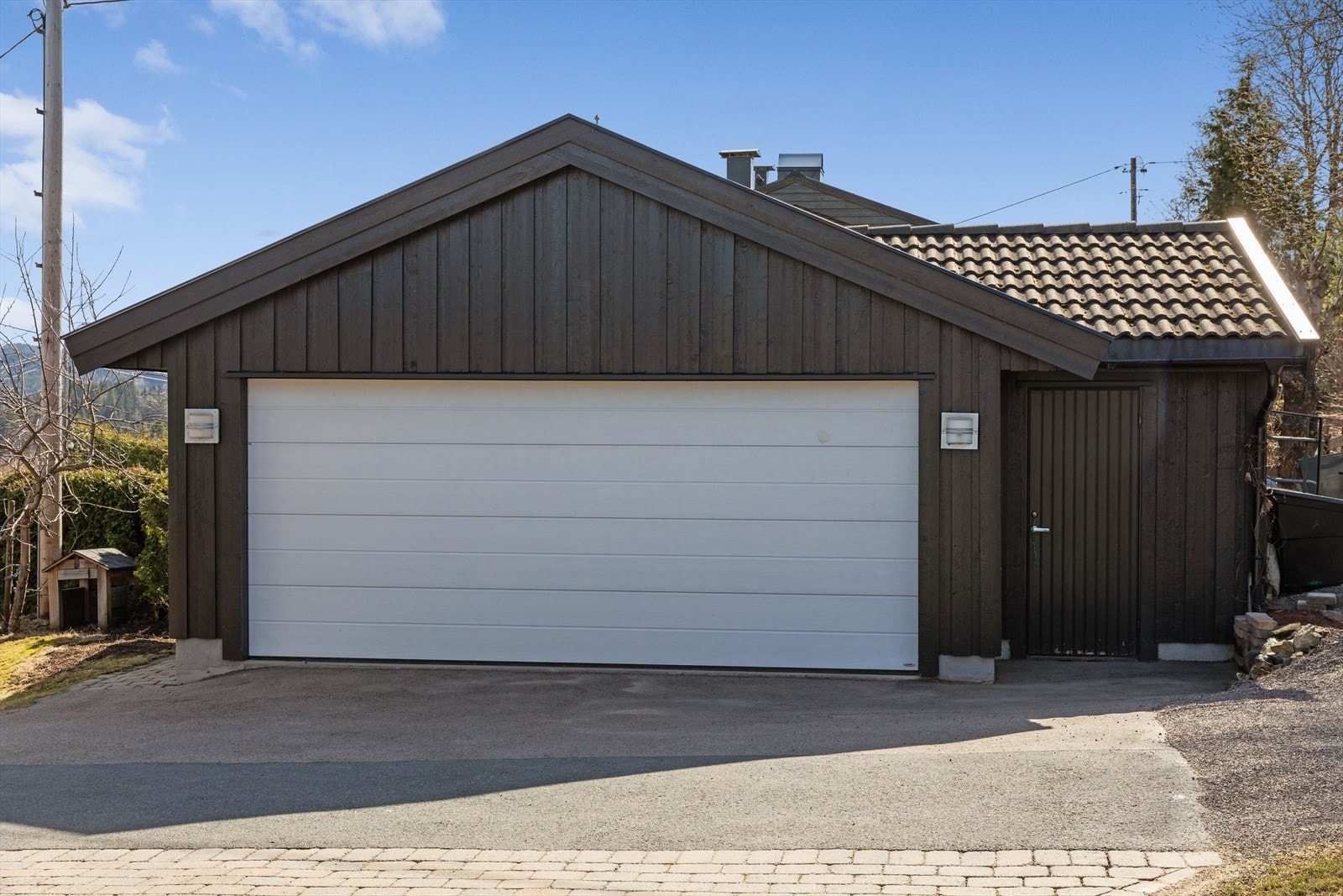 Bilene kan du parkere i garasjen og ved siden av carporten er det ladeboks for el-bilen. Galleribilde