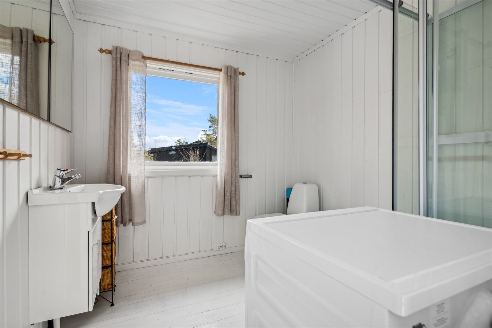 Baderommet er innredet med servant med underskap, speil, dusjkabinett og toalett Galleribilde