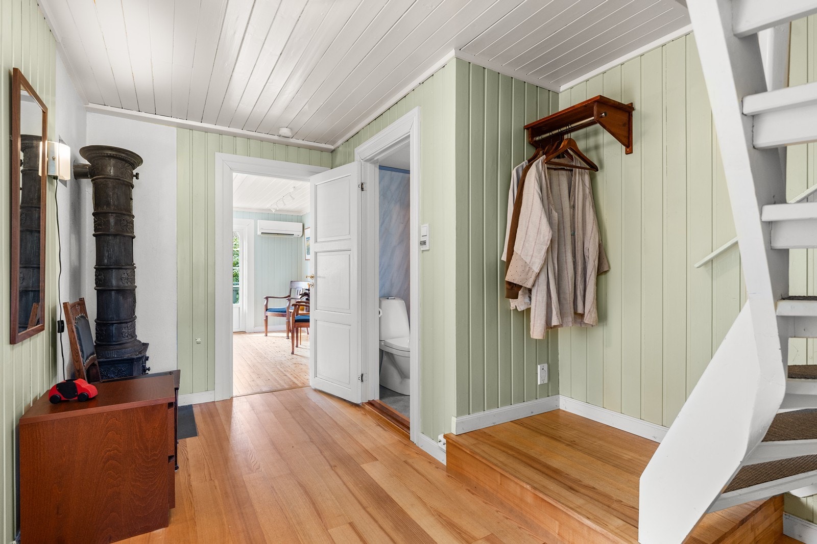 Gang med trapp til 2. etg og en dekorativ etasjeovn Galleribilde