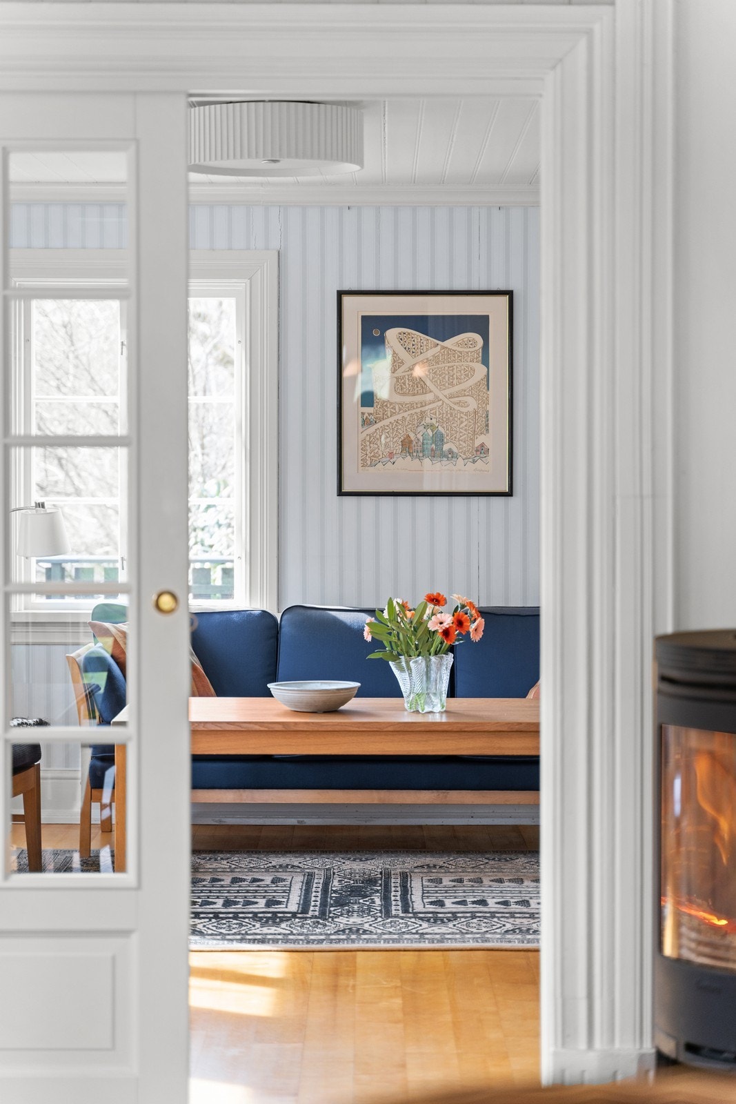 Det er en stor skyvedør med glass mellom kjøkkenet og stuen som sikrer godt gjennomlys i hele etasjen Galleribilde