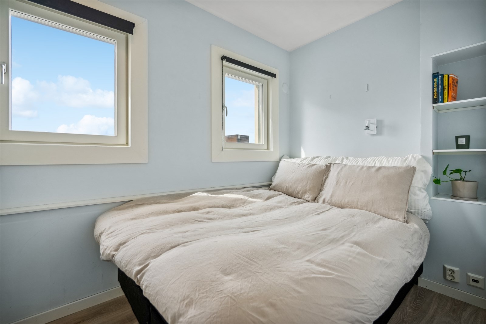 Ved siden av sengen er det en stilig integrert hylleløsning. Galleribilde