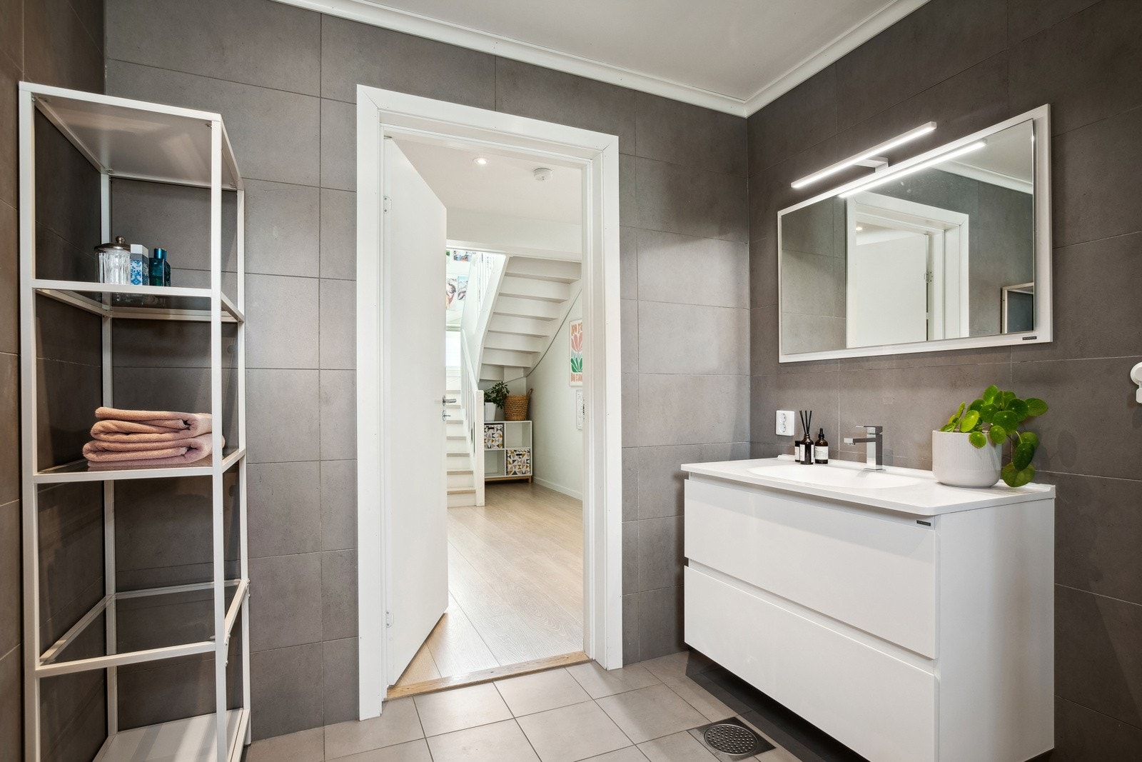 Baderommet har lys innredning med servant, speil med belysning, veggmontert toalett og dusjhjørne. Galleribilde