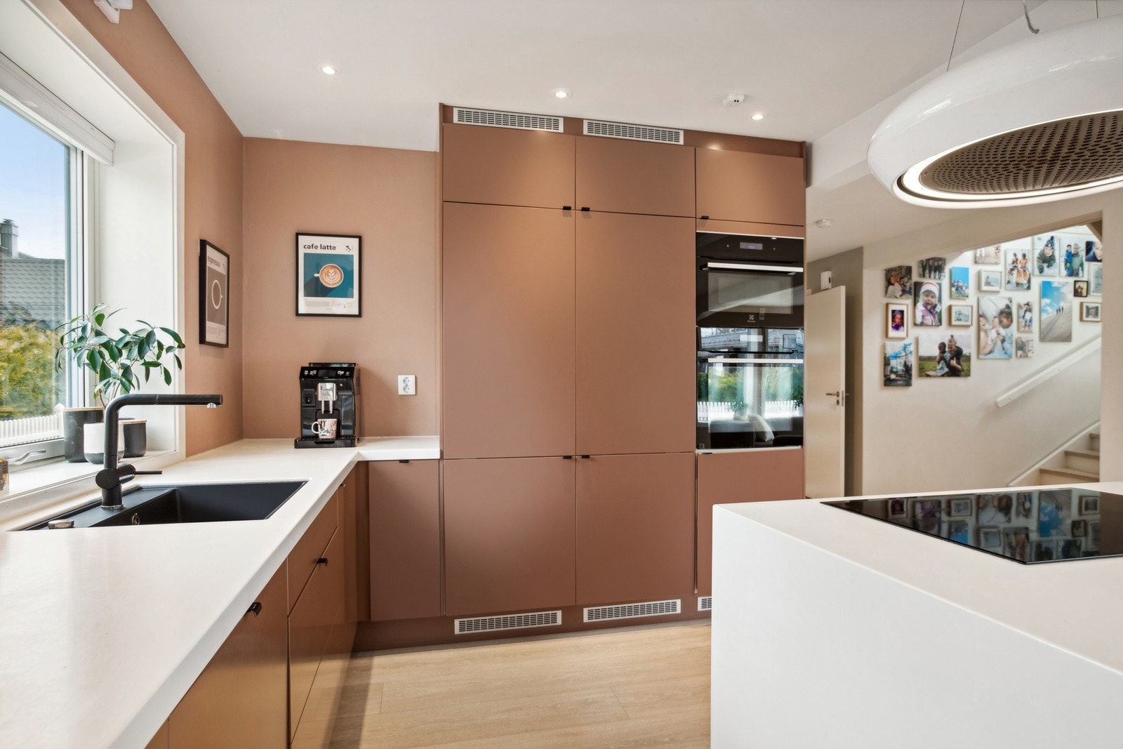 Kjøkkenet har glatte fronter, benkeplater i avonite, oppvaskkum med ett-greps blandebatteri og ventilator over kokesonen. Galleribilde