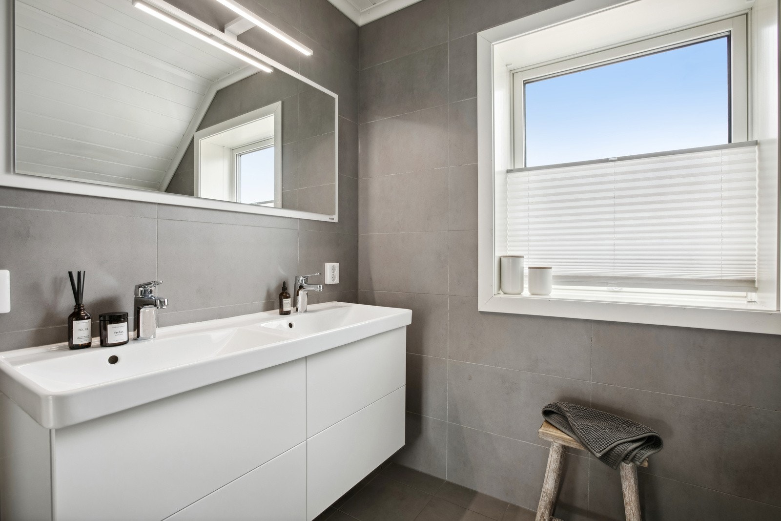 Baderommet har dobbel servant, speil med belysning, veggmontert toalett og deilig badekar. Galleribilde