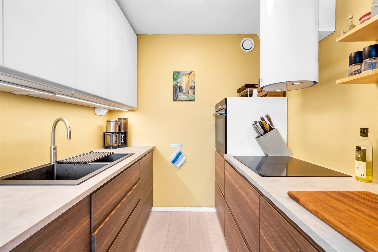 IKEA kjøkkeninnredning med glatte folierte skapfronter, laminat benkeplate, dobbel oppvaskkum og ventilator. Galleribilde