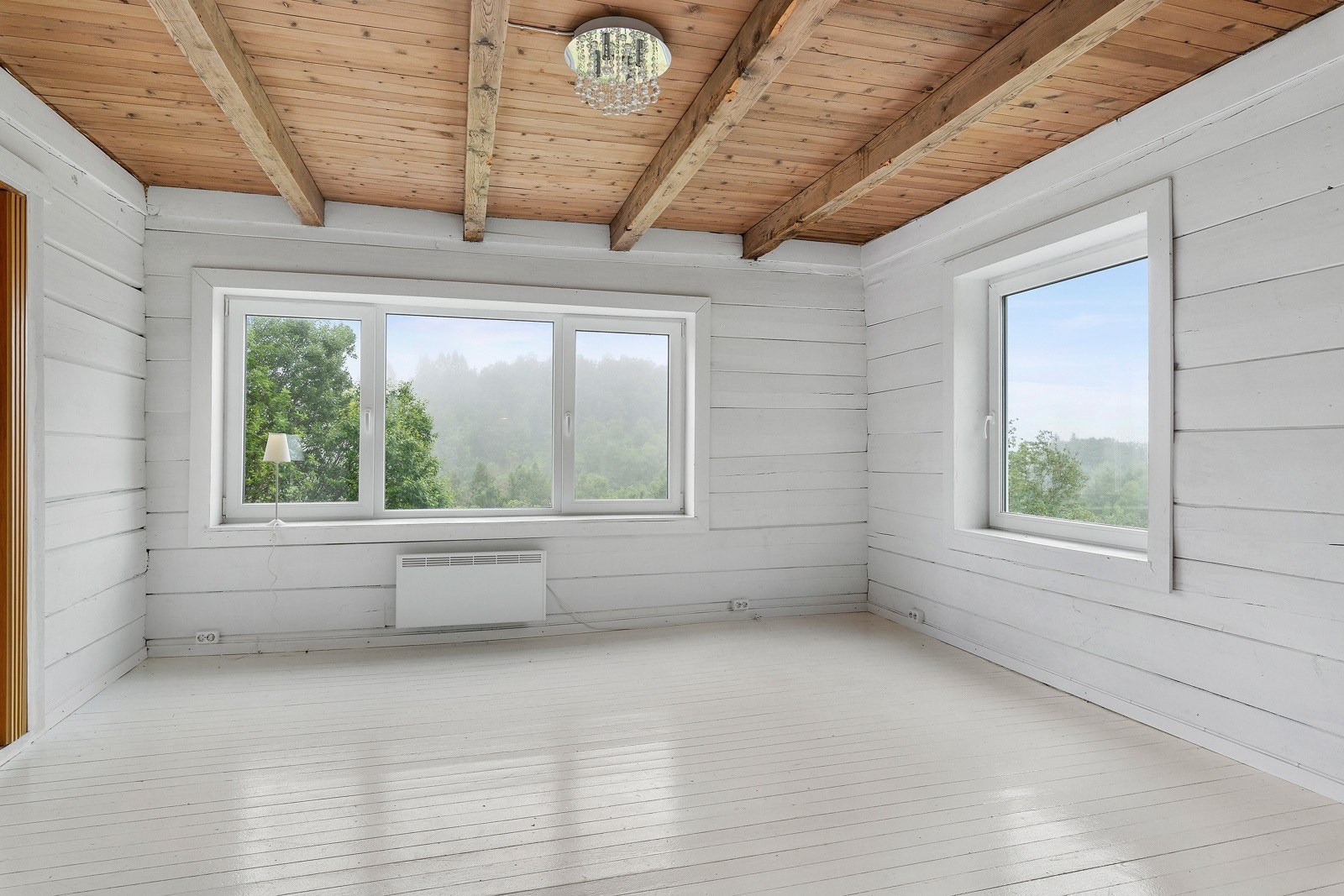 Det er store vindusflater i stuen, med utsikt til nydelig natur. Galleribilde