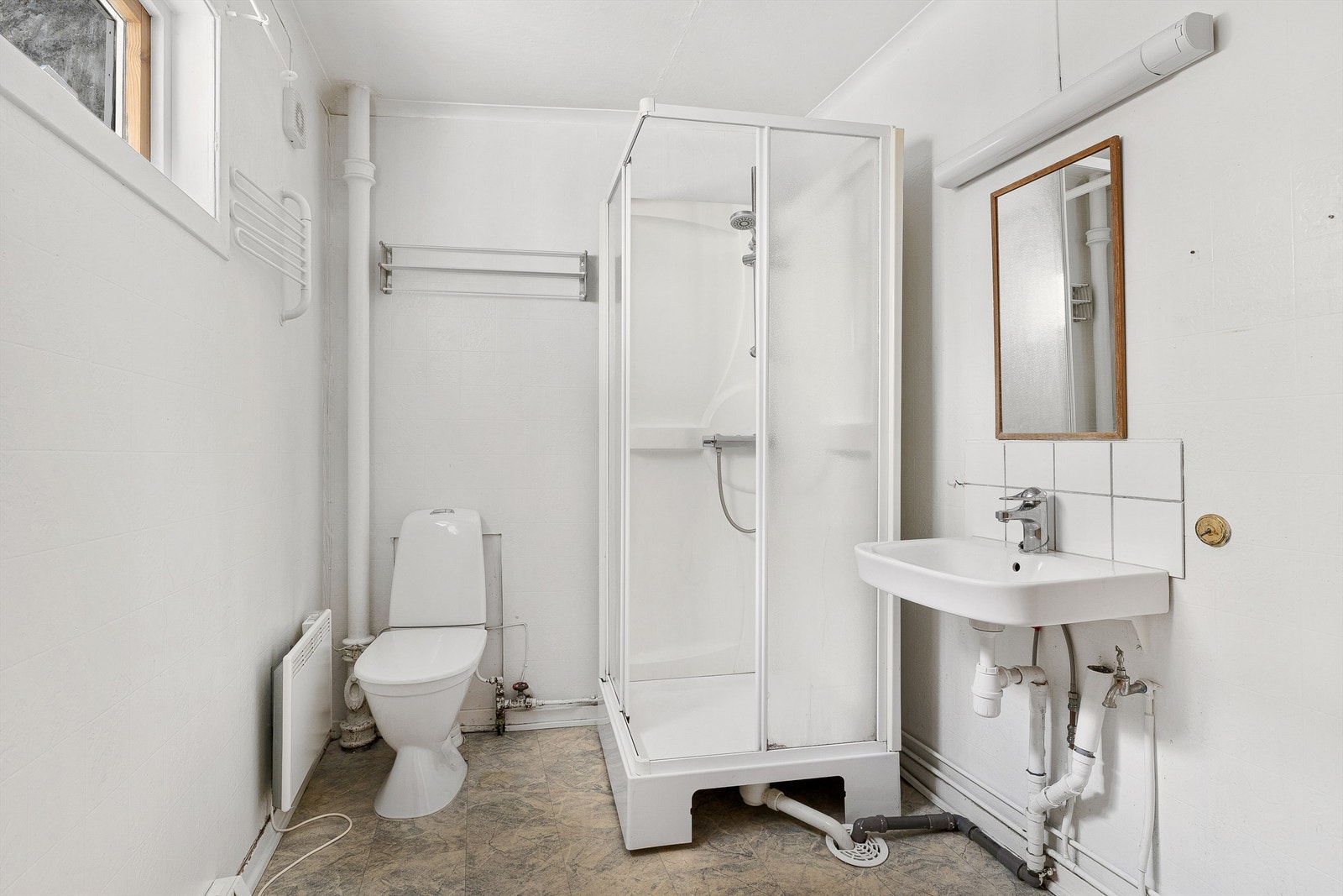 Badet er enkelt og inneholder wc, dusjkabinett og servant. Galleribilde