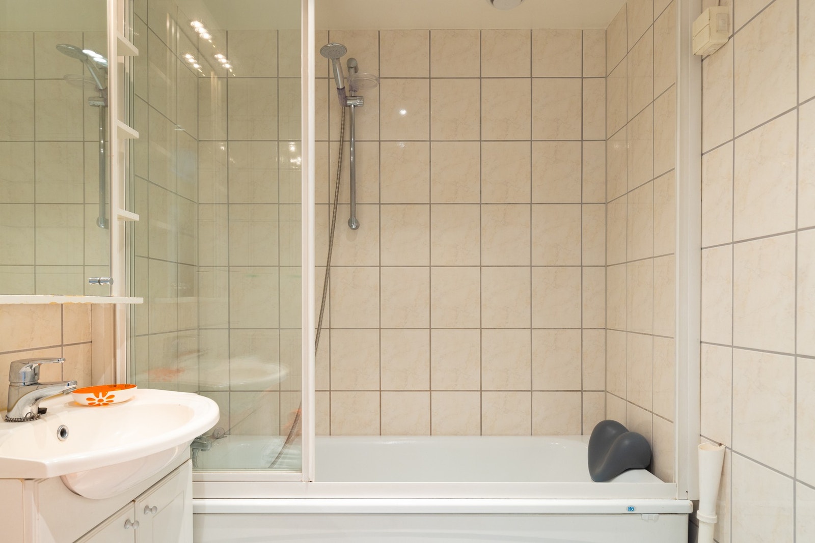 Videre er det gulvstående toalett og badekar med skyvedører og dusjarmatur. Galleribilde