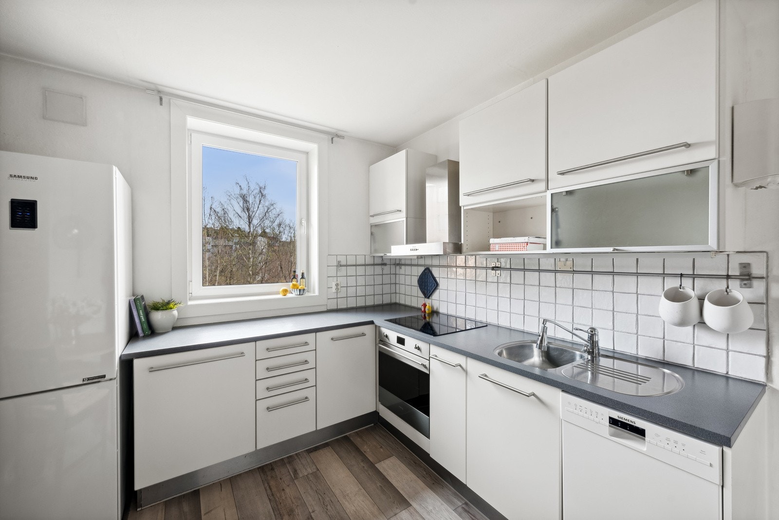 Kjøkken har innfelte hvitevarer med frittstående kjøleskap med fryser. Galleribilde