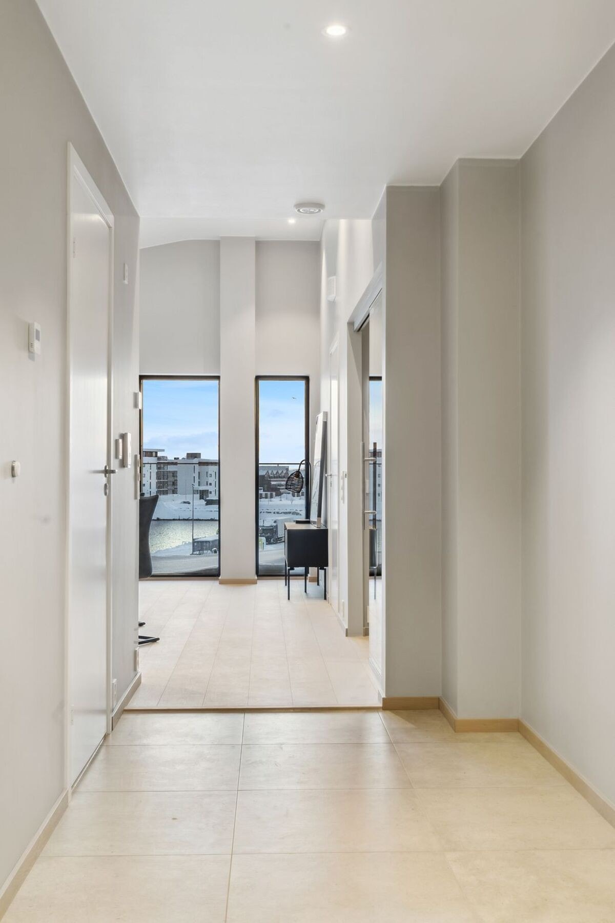 Romslig gang med fliser på gulv, downlights i himling og vannbåren varme. Galleribilde