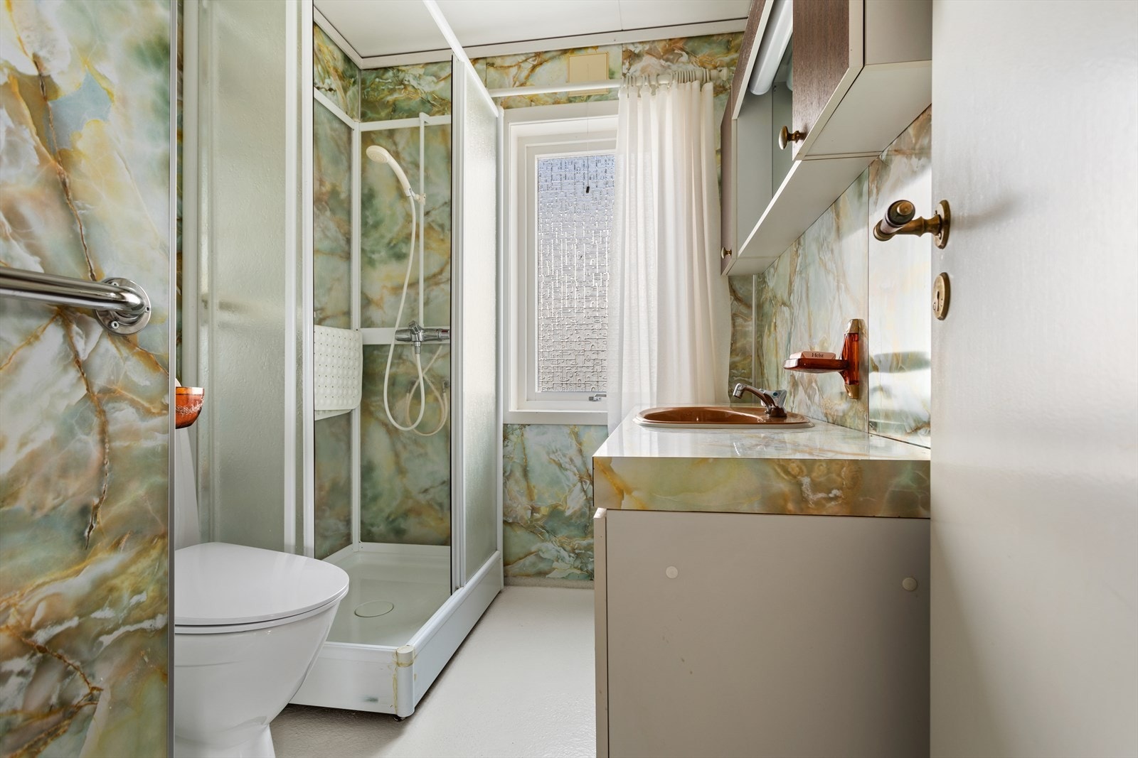 Bad utstyrt med baderomsmøbel med servant, toalett og dusjkabinett. Galleribilde