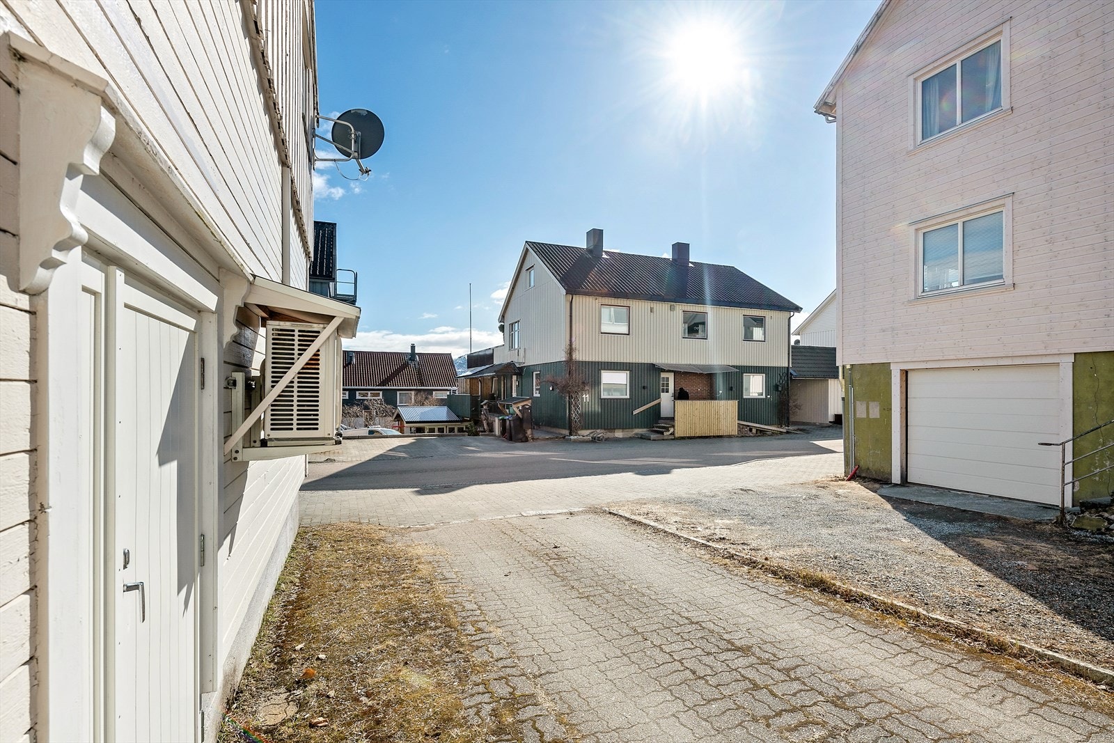 Innkjørsel mot garasje og nedgangsdør til kjeller. Galleribilde