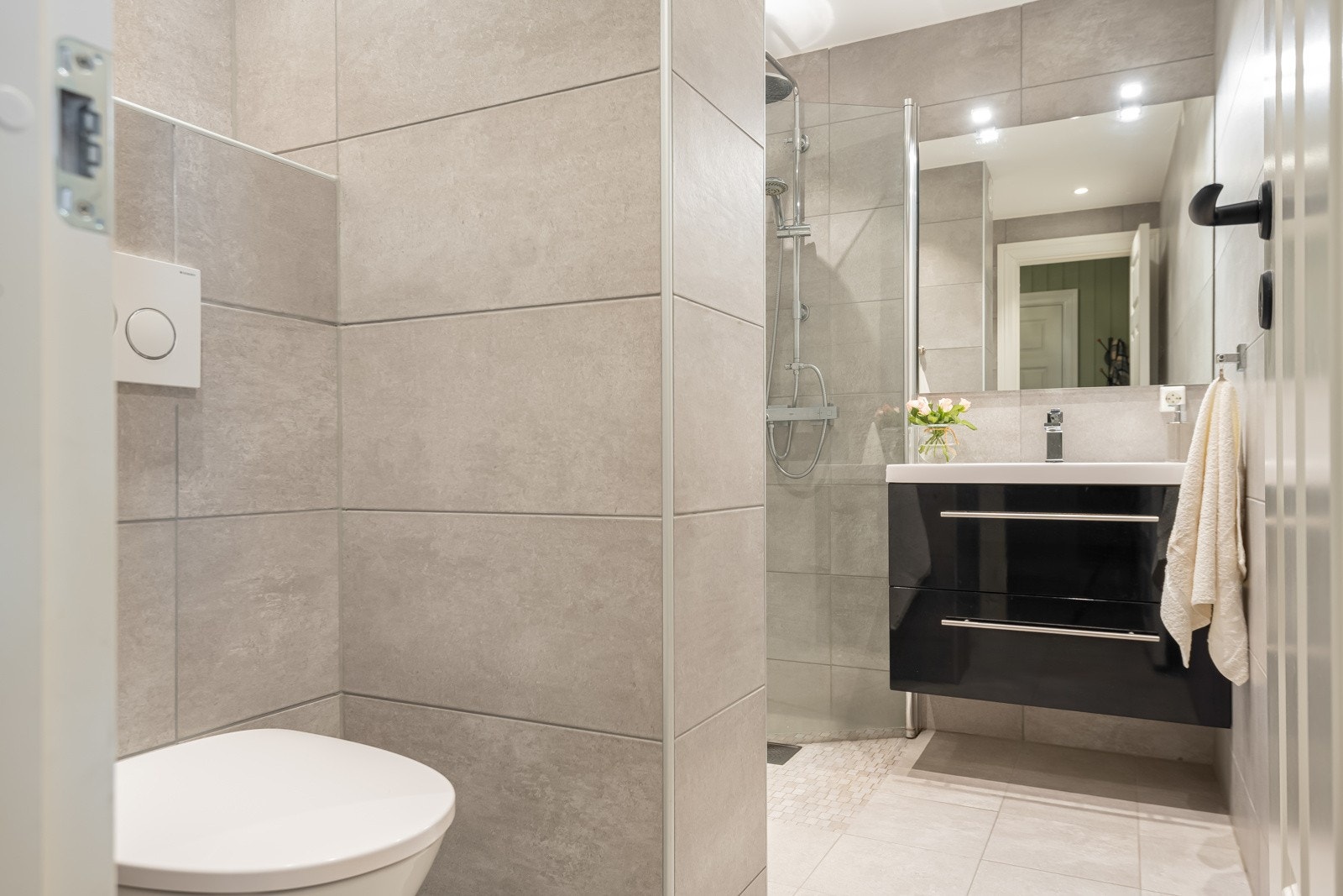 Leiligheten har et lyst og pent bad som har flis på gulv med varmekabler, flis på vegger og malt slett himling med downlights. Galleribilde