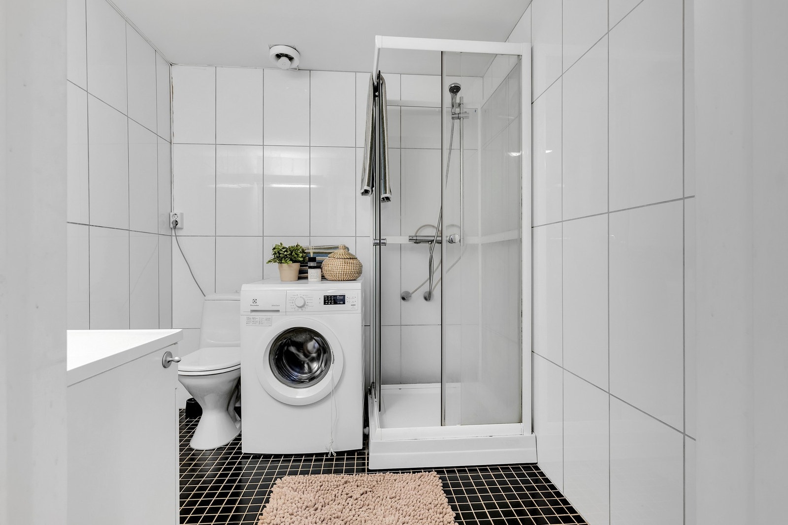 Lyst og flott baderom med opplegg for vaskemaskin. Galleribilde