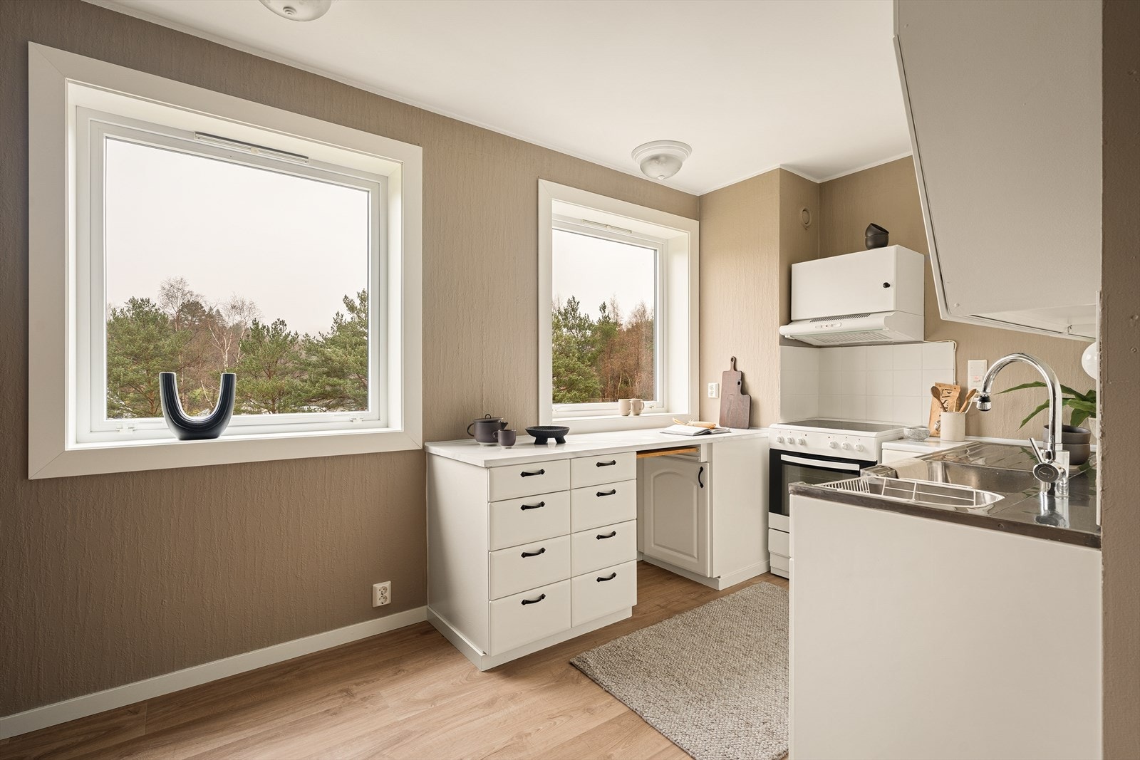 Kjøkkenet består av hvite profilerte fronter, laminat benkeplate, over benkeplate er det benyttet fliser. Det er opplegg for oppvaskemaskin og vaskemaskin. Galleribilde