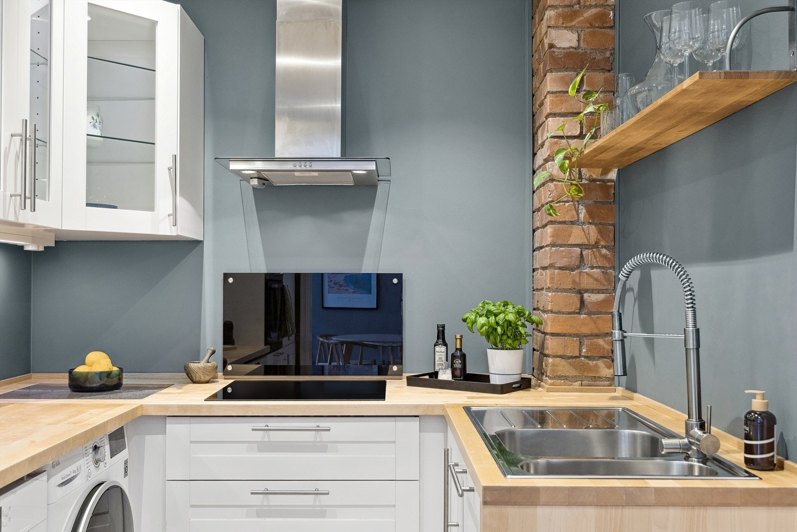 Det er benkeplate i tre med nedfelt stålkum og ett-greps armaturer i krom. Galleribilde