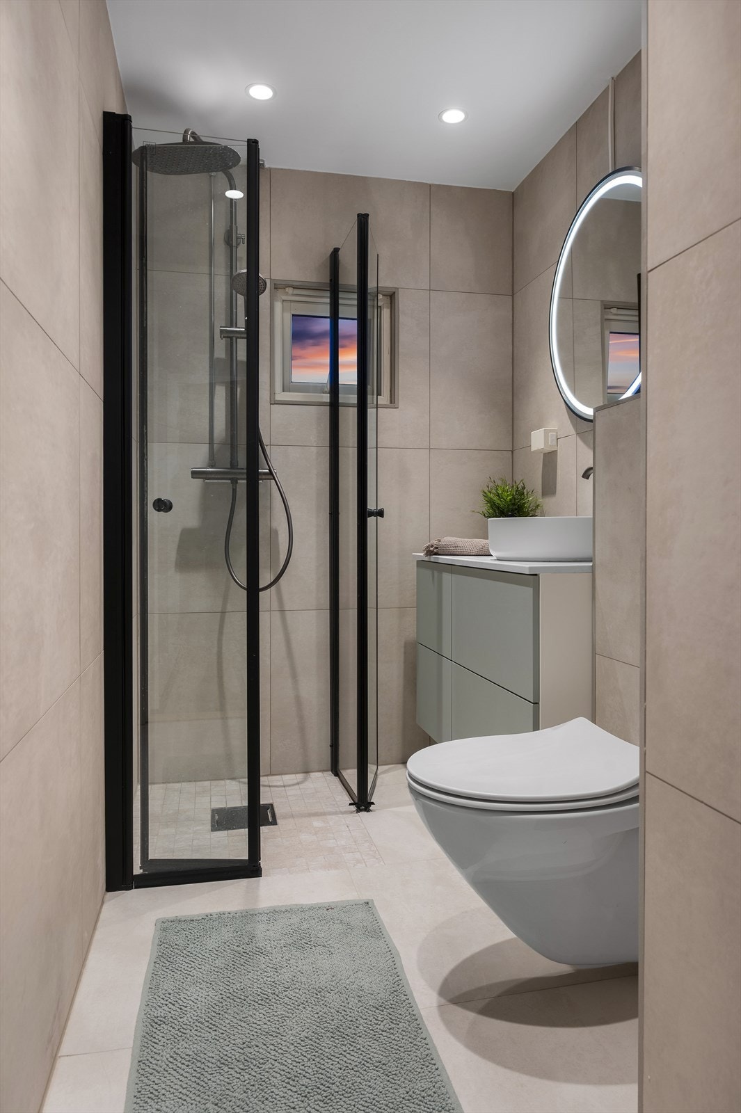 Badet har fått nye overflater og innredning i 2024. Her er det varme i gulv og opplegg for vaskemaskin Galleribilde