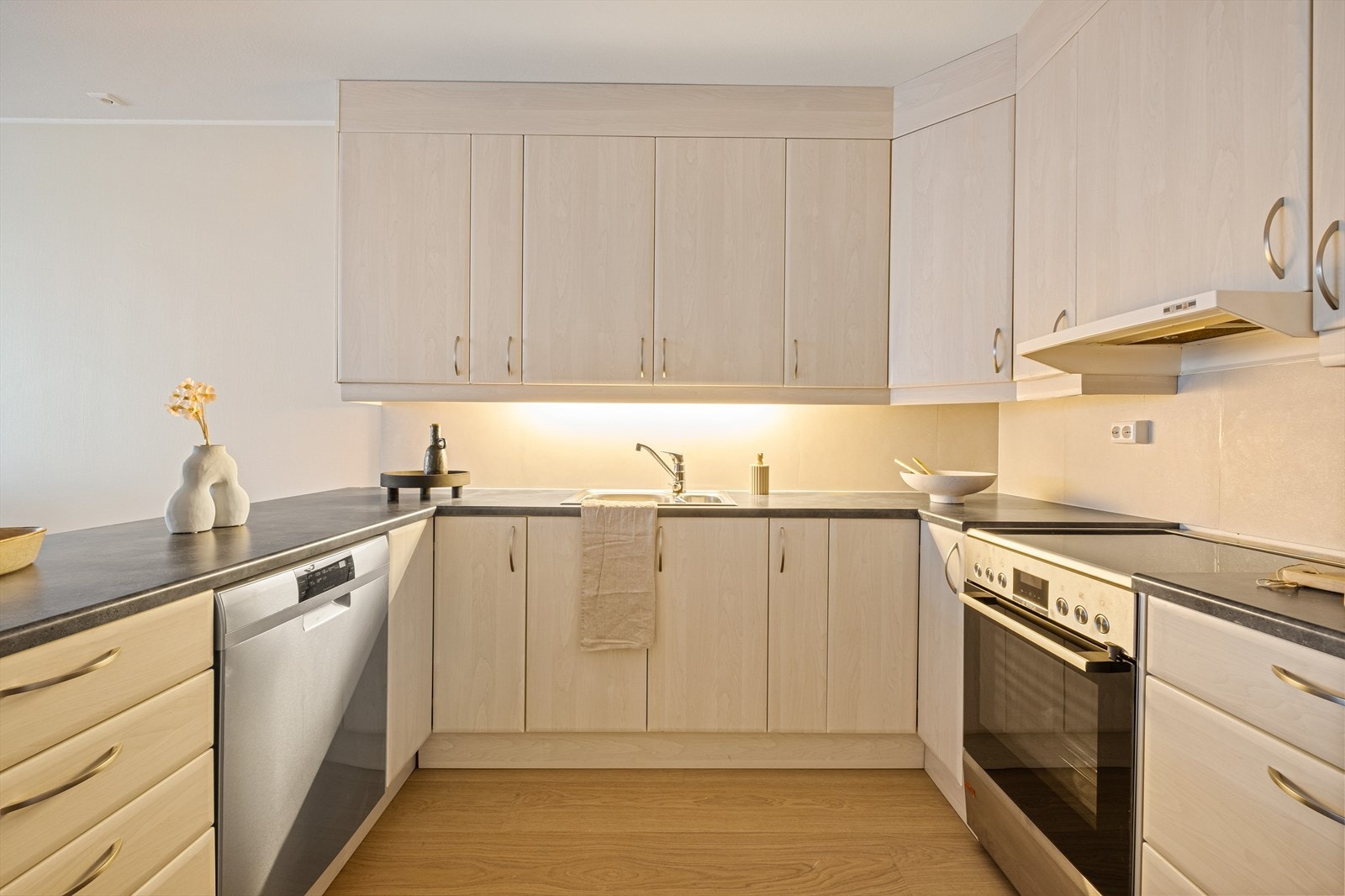 Kjøkkent består av kjøkkeninnredning med slette fronter, laminat benkeplate, over benkeplaten er det benyttet fliser, stål oppvaskkum og ventilator. Galleribilde