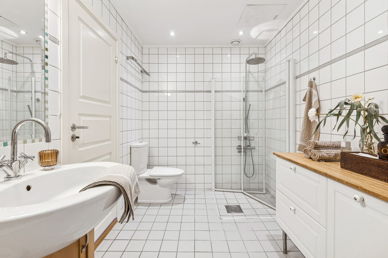 Badet inneholder servant med skap, WC, dusj og badekar. I tillegg er det god plass til oppebevaringsmøblement for håndkle og øvrig. Galleribilde