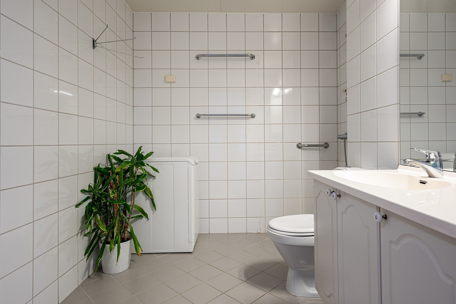 Videre har badet et frittstående toalett, åpent dusjhjørne og opplegg for vaskemaskin. Galleribilde