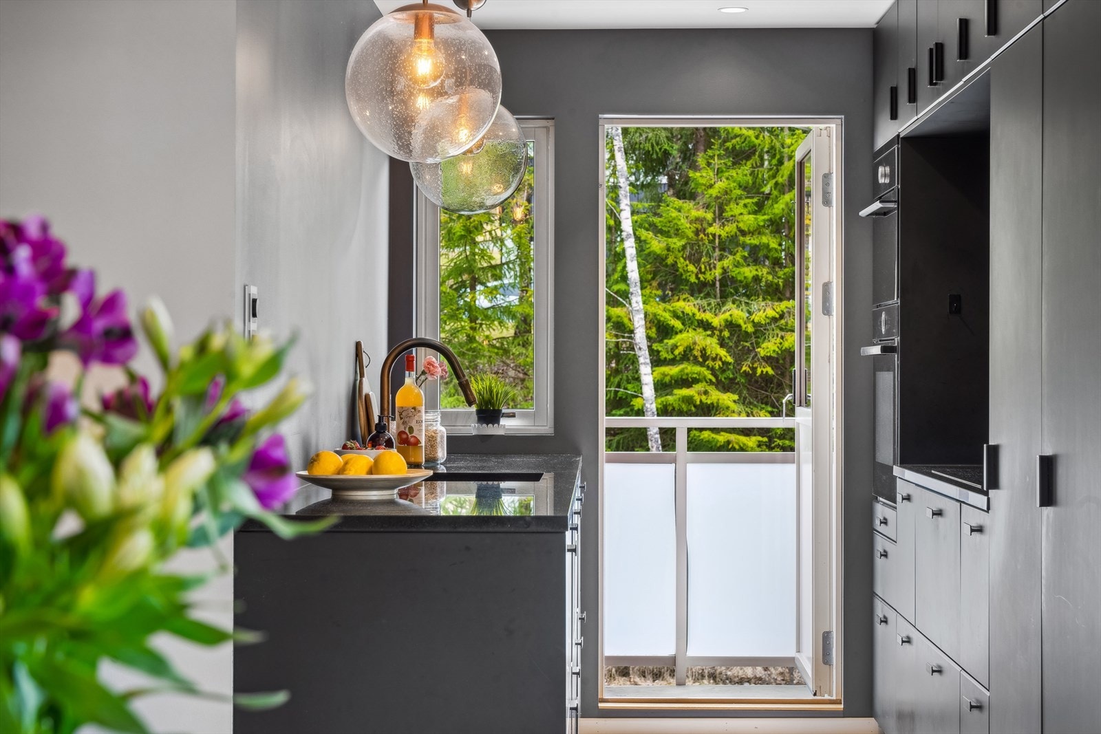 Lekkert kjøkken fra 2019 med massiv benkeplate i polert sort granitt. Galleribilde