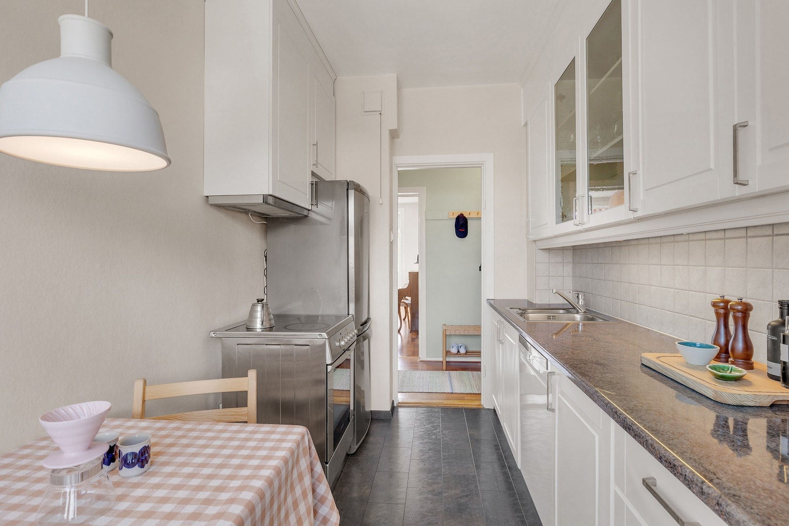 Kjøkkenet har frittstående hvitevarer som kjøl/fryseskap, komfyr og oppvaskmaskin. Galleribilde