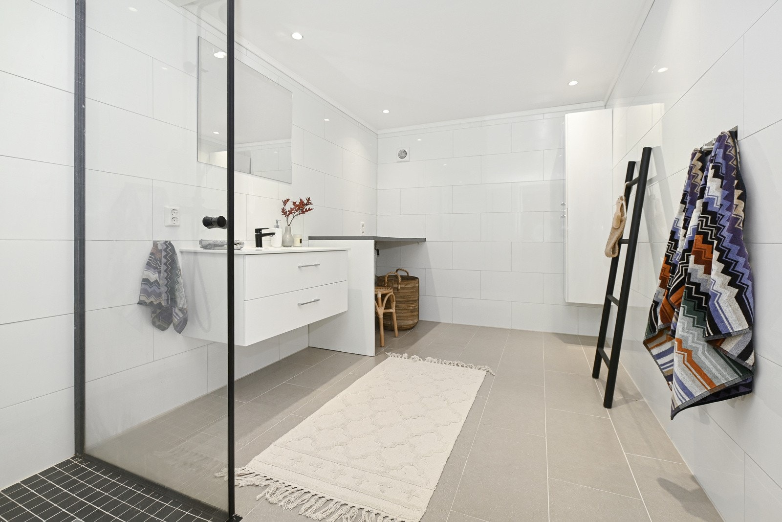 Baderommet i underetasjen har flislagt gulv og varmekabler, og det er liggende hvite fliser på veggene. Galleribilde