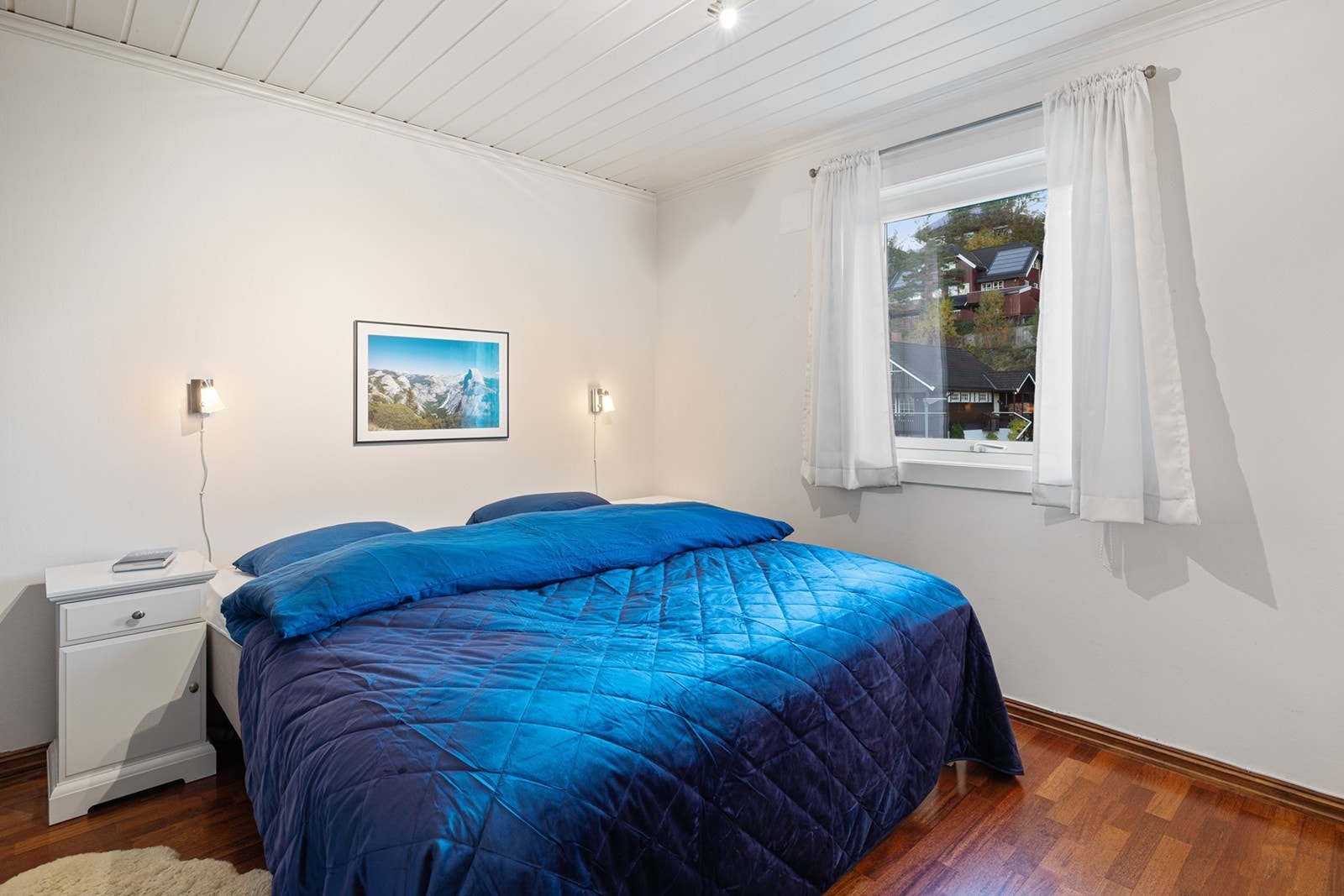 Et lyst og romslig soverom i første etasje med plass til dobbeltseng med tilhørende nattbord. Galleribilde