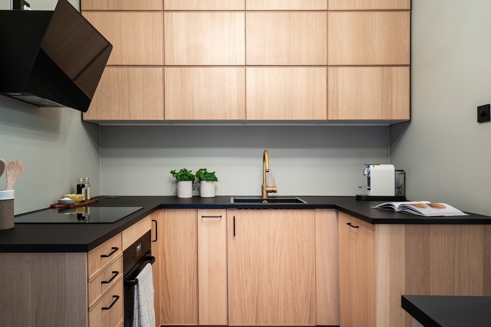 Delikat og moderne kjøkkeninnredning med slette fronter og laminert benkeplate med med integrert koketopp, komfyr, kjøl/frys og oppvaskmaskin. Galleribilde