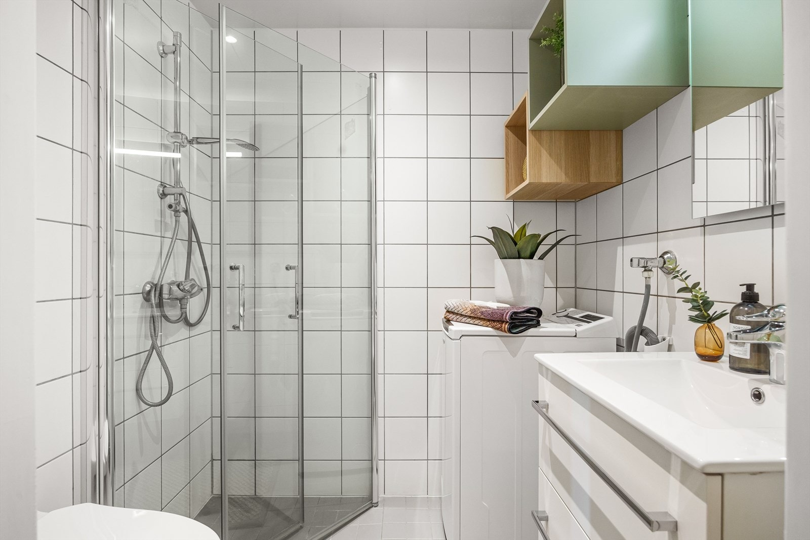 Badet er innredet med vegghengt klosett, servant med innredning og speilskap med lys. Det er opplegg for vaskemaskin. Galleribilde