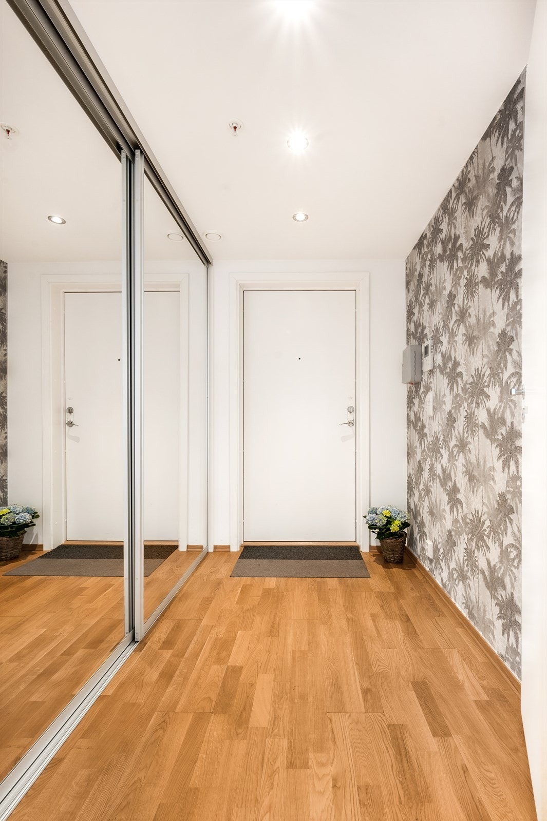 Romslig entré med stor dyp skyvedørsgarderobe med speilfronter. Galleribilde