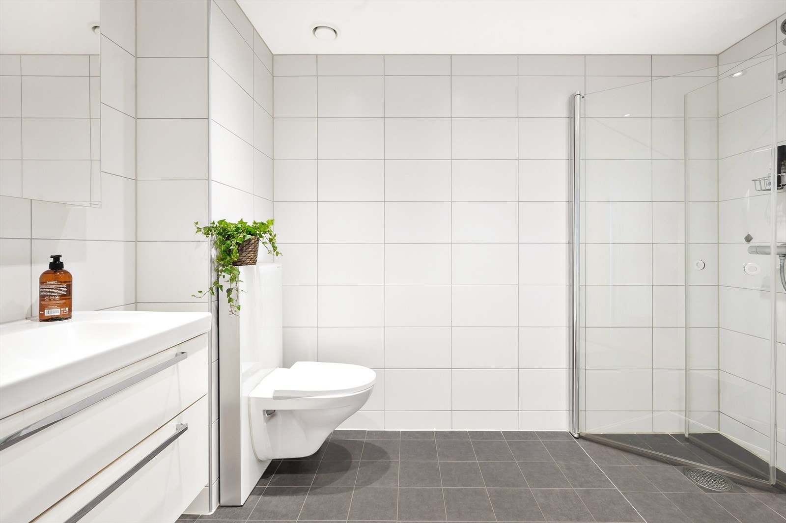 Pent flislagt bad med vegghengt klosett og servant med underskap Galleribilde