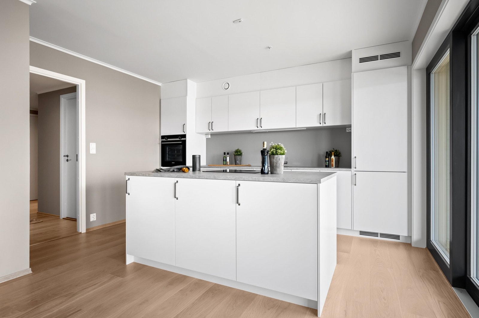 Lekker kjøkken med slette, hvite fronter og integrerte hvitevarer. Galleribilde